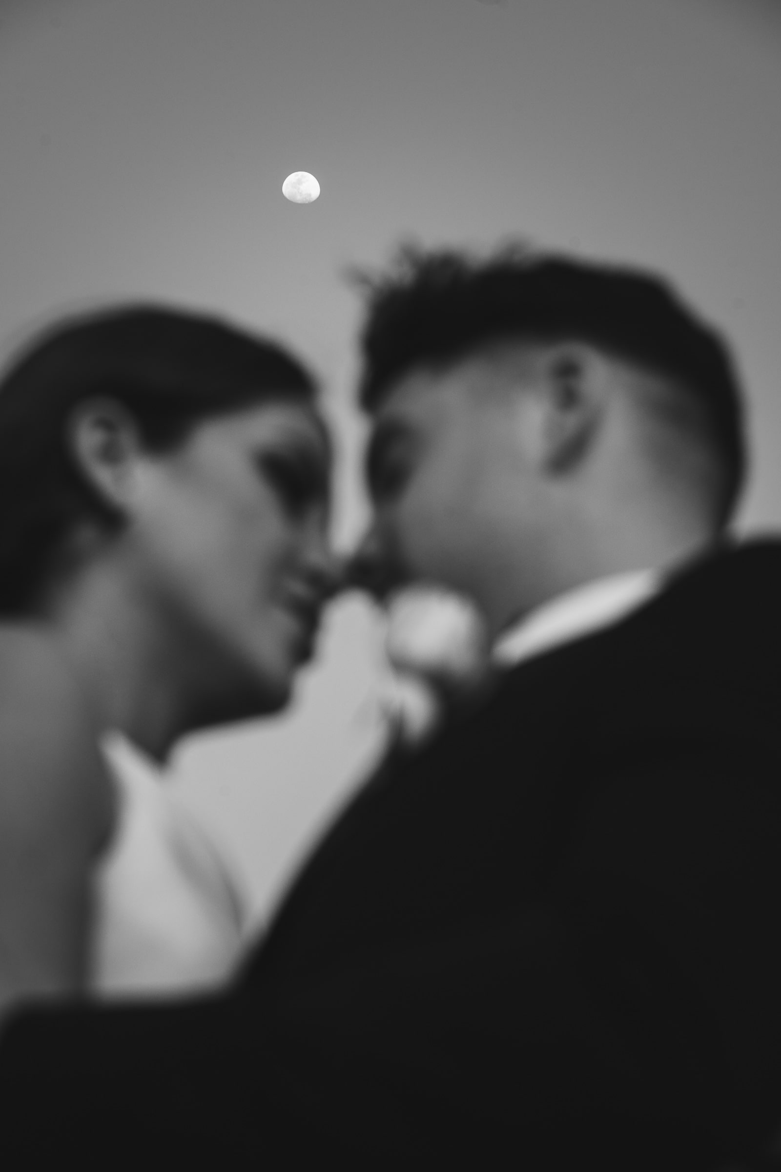 Intimate moment between newly weds with the full moon as a spectator